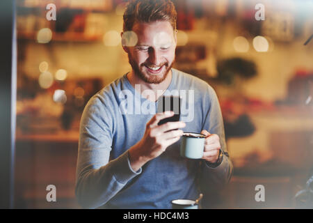 Allegro imprenditore di bere il caffè nella caffetteria Foto Stock