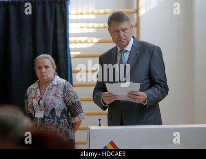 Bucarest, Romania - 05 Maggio 2016: Presidente rumeno Klaus Iohannis getta il diritto di voto nelle elezioni locali. Foto Stock