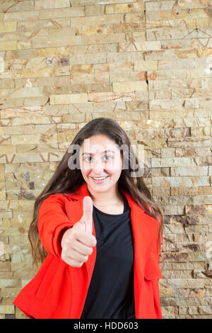 Felice ragazza adolescente che mostra un pollice su mano gesto sorridente Foto Stock