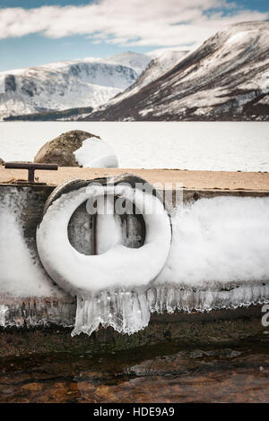 Jetty e le montagne in inverno a Loch Muick in Scozia. Foto Stock