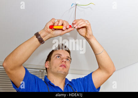 Ritratto di elettricista in Installazione di una nuova lampada in casa Foto Stock