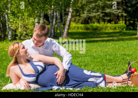 L'uomo abbraccia il suo amato donna incinta nel parco Foto Stock