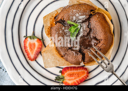 Fondente al cioccolato con fragola e menta su piastra ceramica vista superiore Foto Stock