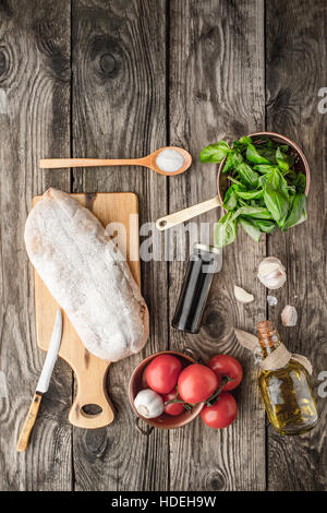 Ingredienti per la bruschetta sul tavolo di legno Foto Stock