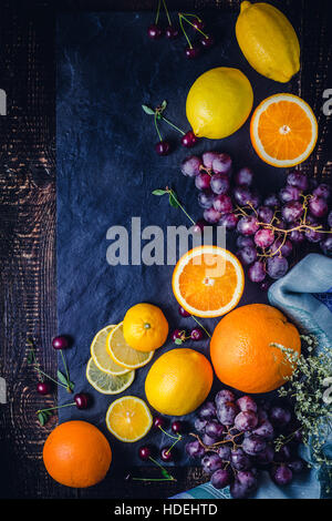 Frutta diversa sullo sfondo scuro in verticale Foto Stock