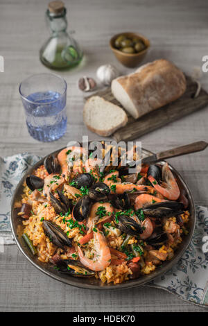 La paella in lastra di metallo sul tavolo di legno Foto Stock