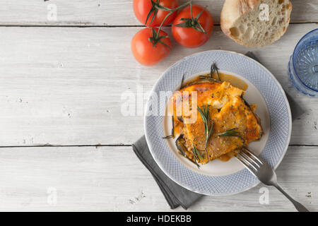 Mangiare la moussaka nel tavolo bianco con pomodori e pane vista superiore Foto Stock