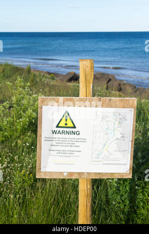 Avviso inviato vicino Hauxley riserva naturale, Duridge Bay, Northumberland, avviso di fori di coppa e sabbie mobili sulla spiaggia Foto Stock