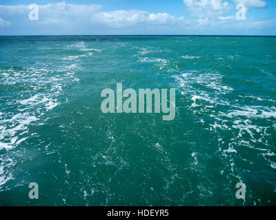 Riattivazione di un yacht nel calmo mare verde, cielo blu con nuvole bianche Foto Stock
