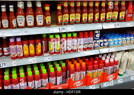 Ripiani con una diversa gamma di ketchup prodotti in un supermercato REWE Foto Stock