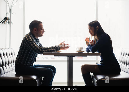 Scena in cafe - giovane conflitto sostenendo durante il pranzo. Foto Stock