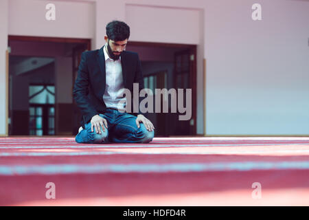 Giovane uomo musulmano in preghiera nella moschea colorati Foto Stock