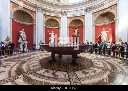 Vaticano, Italia - 2 Novembre 2016: Visitatori vicino statue, Hercules figura e rotonda monolitica bacino di porfido nella Sala Rotonda del Museo Pio-Clementino ho Foto Stock