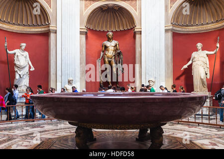 Vaticano, Italia - 2 Novembre 2016: turisti e statue romane, Hercules scultura e round monolitico bacino di porfido nella Sala Rotonda del Pio-Clementino Foto Stock