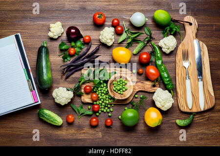 Verdure su legno. Bio cibo sano, erbe aromatiche e spezie. Verdure organiche su sfondo di legno Foto Stock