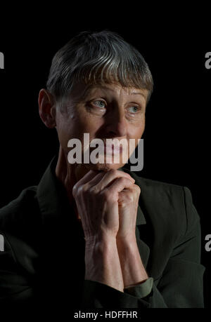 Donna con mani giunte e uno sguardo pieno di speranza, 60+ Foto Stock