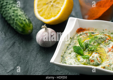 Tzatziki sul tavolo di pietra con il cetriolo , Limone e orizzontale di stagionatura Foto Stock