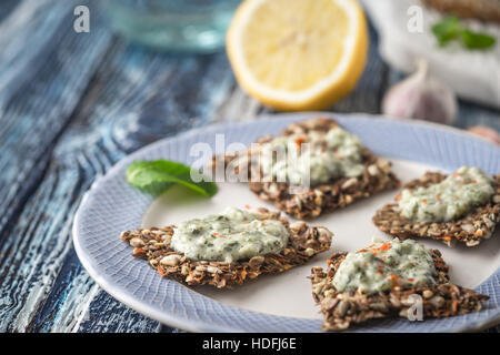 Croccante pane di grano con tzatziki sulla ceramica blu piastra in orizzontale Foto Stock