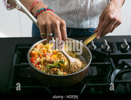 Giovane donna indiana in cucina a preparare il cibo ayurvedico Foto Stock
