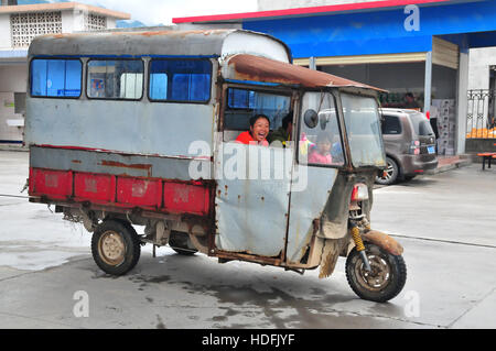 Un giovane e la loro figlia amano cavalcare nel loro moto camion sulle strade di Yangshuo Guilin. Foto Stock