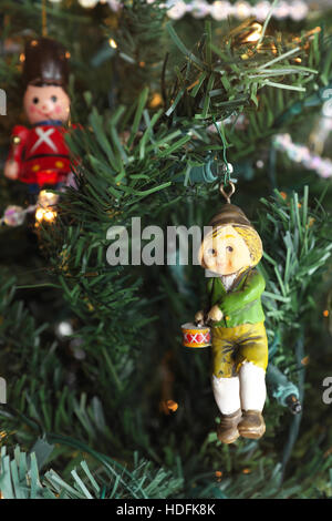 Decorazione per albero di Natale appeso sulla struttura ad albero con il focus sulla Little Drummer Boy. Un soldato giocattolo si blocca in background. Foto Stock