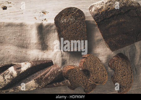 Fette di pane sul tovagliolo sulla tavola di legno vista superiore Foto Stock