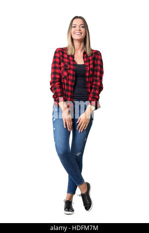 Spontaneamente a ridere rilassata piuttosto giovane donna informale in jeans e maglietta scozzese. Corpo pieno lunghezza ritratto isolato su bianco Foto Stock