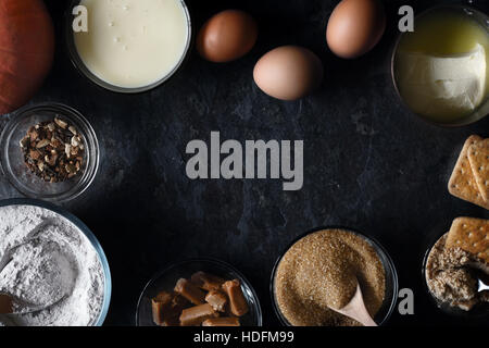 Telaio di ingredienti per la zucca torta dump sulla pietra scura sullo sfondo vista superiore Foto Stock