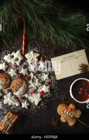 Palla di Natale realizzata dai cookie sullo sfondo di legno con diversi accessori Foto Stock