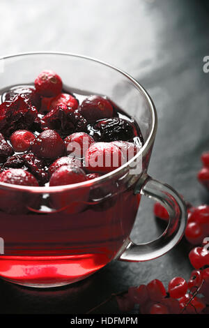 Tazza di tè con frutti di bosco in pietra scura tabella Foto Stock