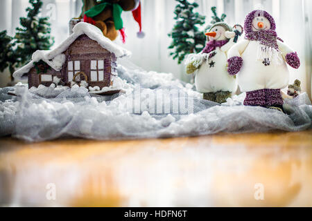 Merry Christmas Card con felice pupazzi di neve vicino a casa loro inverno indossare sciarpe e cappelli, con spazio di copia Foto Stock