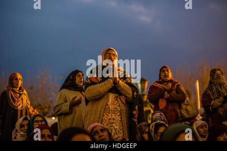 Srinagar Kashmir. 12 Dic, 2016. Kashmir donne musulmane devoti guardano verso un chierico visualizzando la sacra reliquia si ritiene essere il baffo dalla barba del Profeta Maometto, al Santuario Hazratbal durante l'Eid-e-Milad, o l'anniversario di nascita del Profeta Mohammad su dicembre 12, 2016 a Srinagar, la capitale estiva di Indiano Kashmir amministrato, India. Credito: ZUMA Press, Inc./Alamy Live News Foto Stock