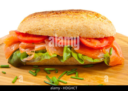 Salmone affumicato su pane alle erbe e il piatto in legno Foto Stock