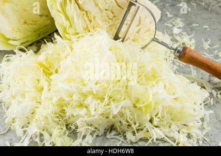 Cavolo tagliato a fette e coltello da cucina attrezzo sul tavolo di pietra Foto Stock