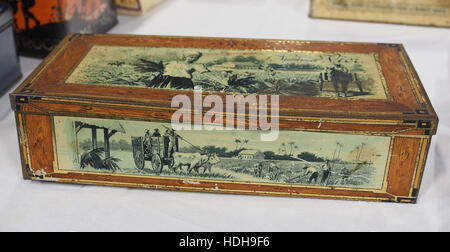 Questa immagine mostra una scatola di sigari vintage etichettata "Nummer Vier", che evidenzia un marchio specifico di sigari. Lo stagno risale probabilmente all'inizio del XX secolo, con elementi di design tipici dell'epoca, tra cui il marchio e i motivi decorativi associati ai prodotti del tabacco dell'epoca. Foto Stock