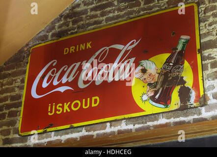 Questa pubblicità in smalto della Coca-Cola, risalente all'inverno del 1944, è in mostra in un museo di Gingelom. L'opera riflette le tendenze del design degli anni '1940 e il ruolo significativo della Coca-Cola nella pubblicità durante la seconda guerra mondiale, quando il marchio era centrale per la cultura e l'economia del tempo di guerra americano. Foto Stock