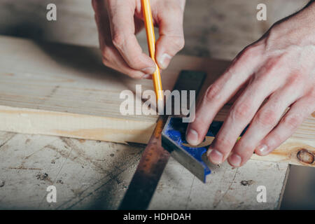 Mani tagliate di carpenter marcatura sulla doga con matita e righello in officina Foto Stock