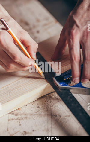 Mani tagliate di carpenter marcatura sulla doga con matita e righello in officina Foto Stock