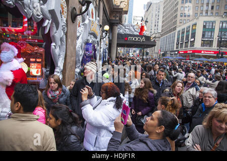 Una folla di gente che erano a magazzino Macy's shopping e la visualizzazione delle vacanze di Natale di windows su Broadway sul Venerdì nero il giorno dopo il ringraziamento che segna l'inizio della vacanza dono stagione degli acquisti in NYC. Foto Stock