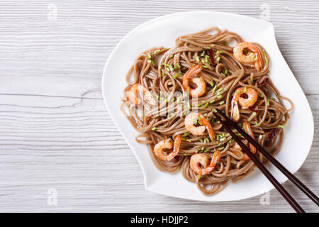 Soba con gamberi e bastoncini su una piastra orizzontale di vista da sopra Foto Stock