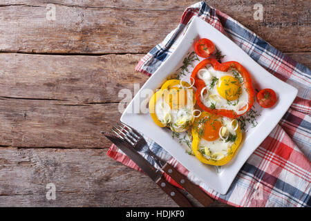 Uova fritte in giallo e peperoni rossi su una piastra orizzontale di vista da sopra Foto Stock