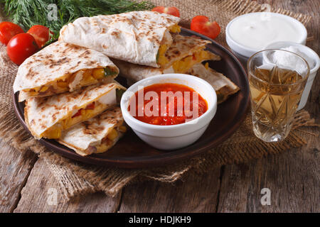 Affettato quesadilla con il pollo e le verdure su una piastra di close-up orizzontale. Foto Stock