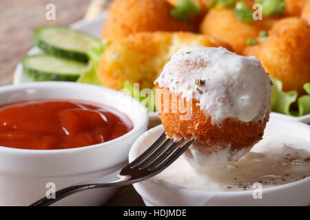 Fritti crocchette di patate con panna acida di close-up in stile rustico, orizzontale Foto Stock