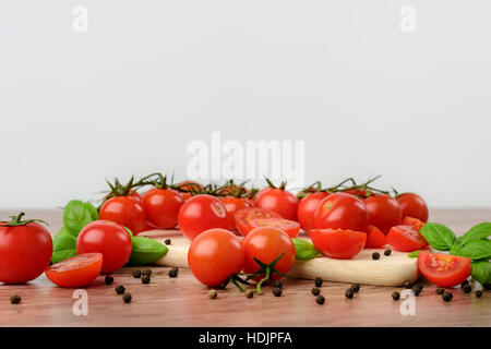 Mini tomaotes sul tavolo di legno con sfondo luminoso. Foto Stock