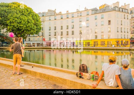 I giovani in un momento di relax a Canal Saint Martin al crepuscolo, quai de Jemmapes guardando quai de valmy Foto Stock