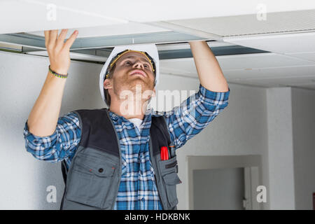 Elettriche Cablaggio lavoratore nel soffitto Foto Stock