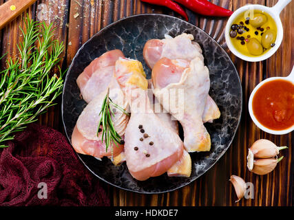 Cosce di pollo sulla piastra e su una tavola Foto Stock