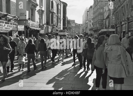 Foto in bianco e nero di folla facendo la loro strada attraverso il Leicester Square area in Londra su una soleggiata giornata d agosto. Foto Stock