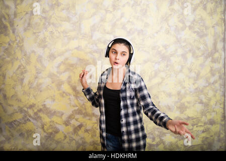 Pretty girl dancing in plaid shirt con cuffia Foto Stock