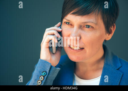 Irritato arrabbiato business woman mobile durante la conversazione telefonica che mostra i suoi denti Foto Stock